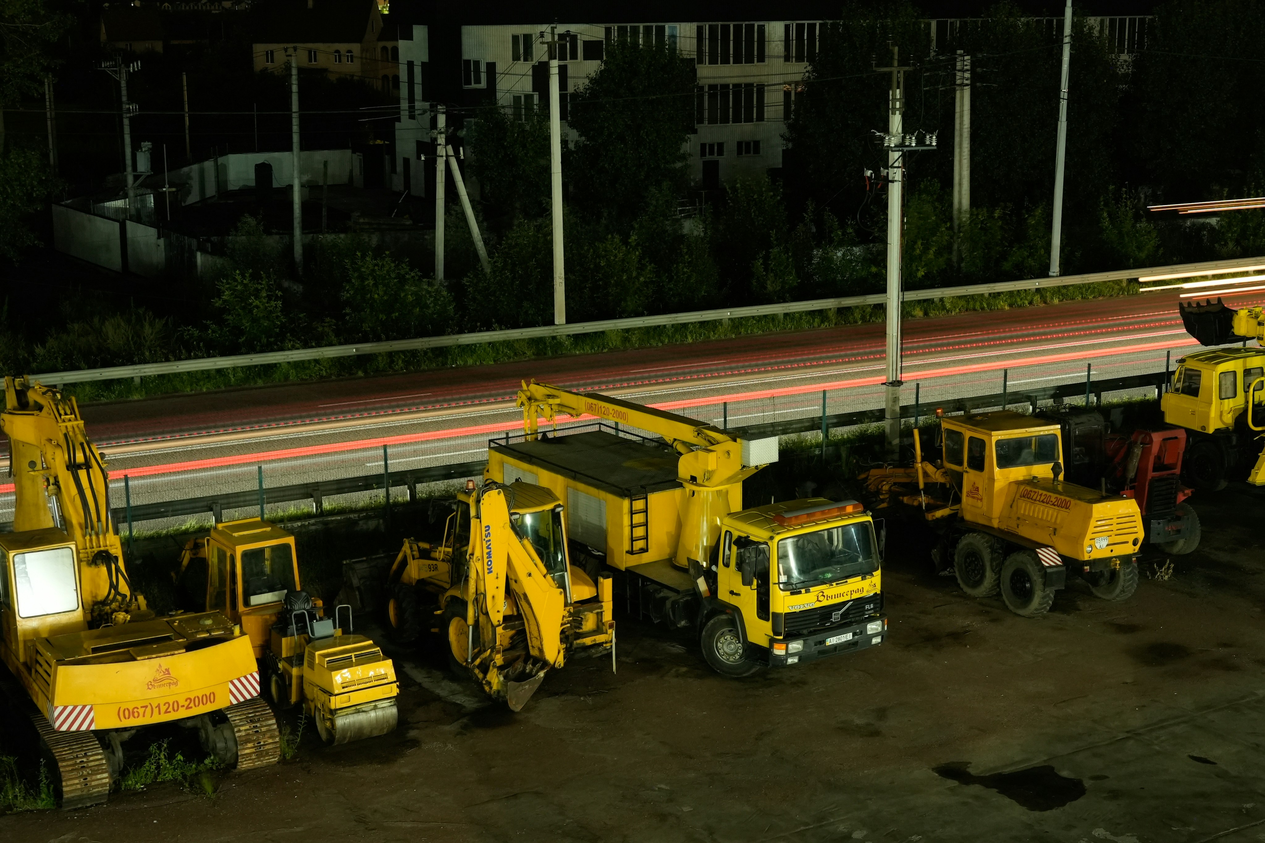 A group of construction trucks parked next to each other